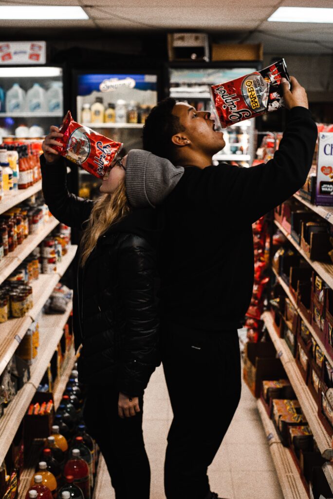 two people eating chips in store