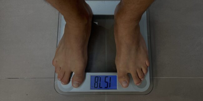 Man weighing himself on bathroom scale