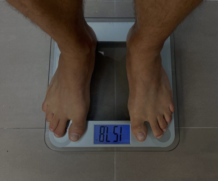 Man weighing himself on bathroom scale