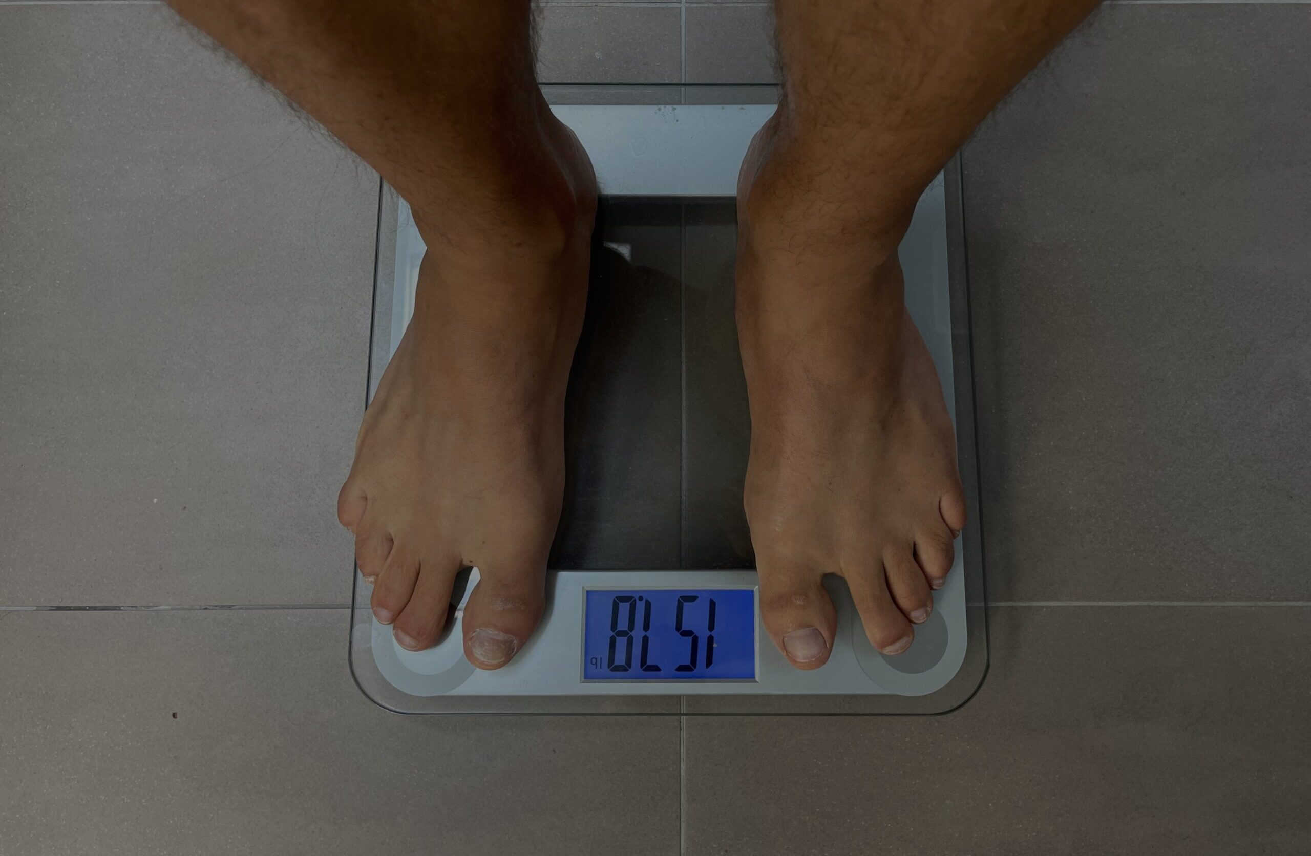 Man weighing himself on bathroom scale