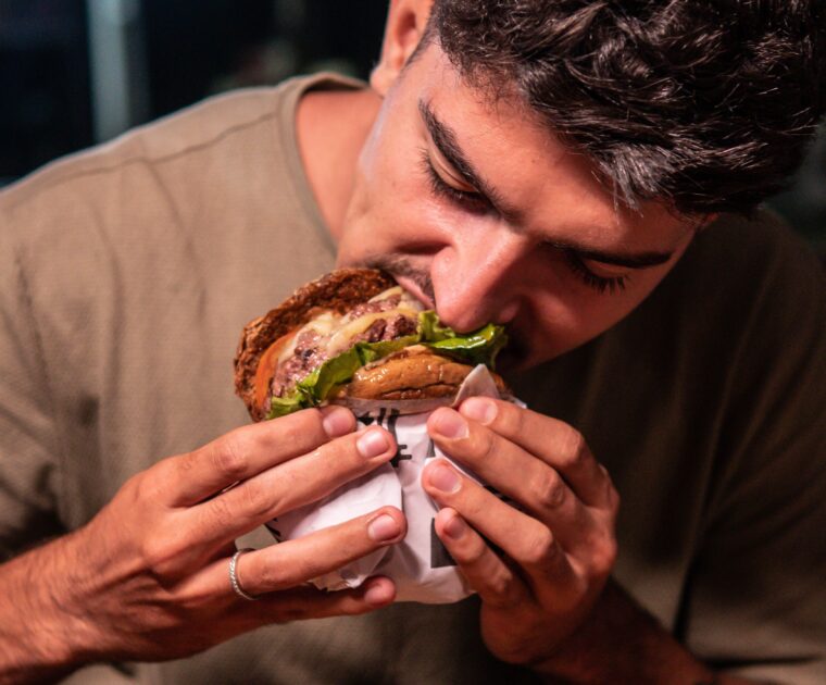 The Food World Keeps Upgrading the Menu While Leaving the Eater Untouched. man eating burger. Knowing what to eat doesn't always help.